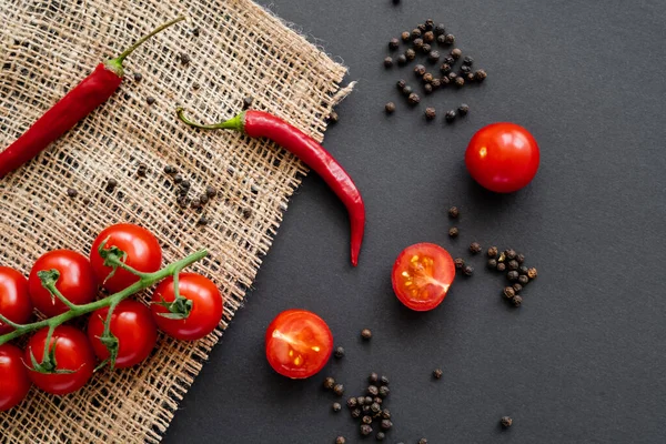 Top view of vegetables near peppercorns on sackcloth on black background — Stock Photo