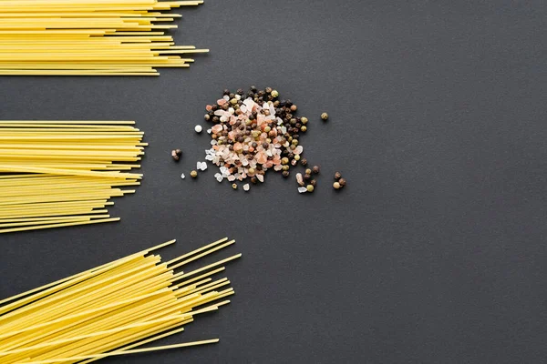 Vista dall'alto di spaghetti crudi e spezie su sfondo nero — Foto stock