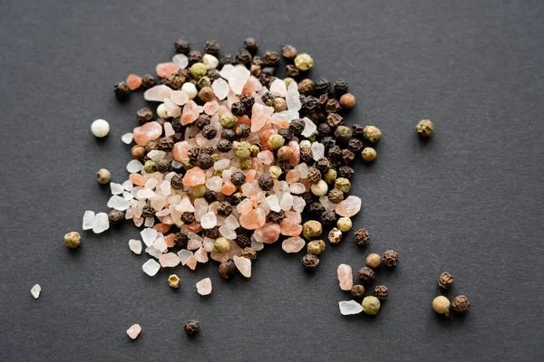 Close up view of salt and peppercorns on black background — Stock Photo