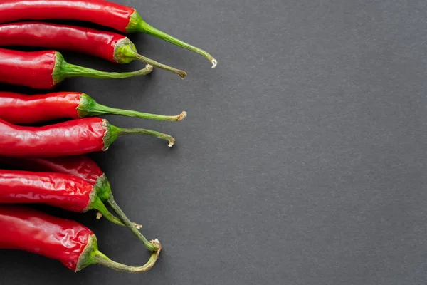 Top view of chili peppers on black background with copy space — Stock Photo