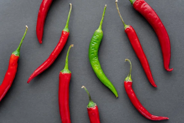 Top view of green and red chili peppers on black background — Stock Photo