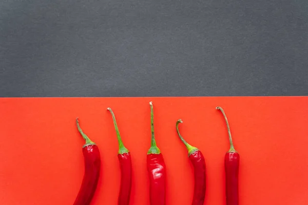 Top view of chili peppers on red and black background — Stock Photo