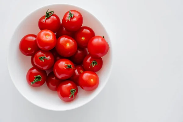 Draufsicht auf frische Kirschtomaten in Schüssel auf weißem Hintergrund — Stockfoto