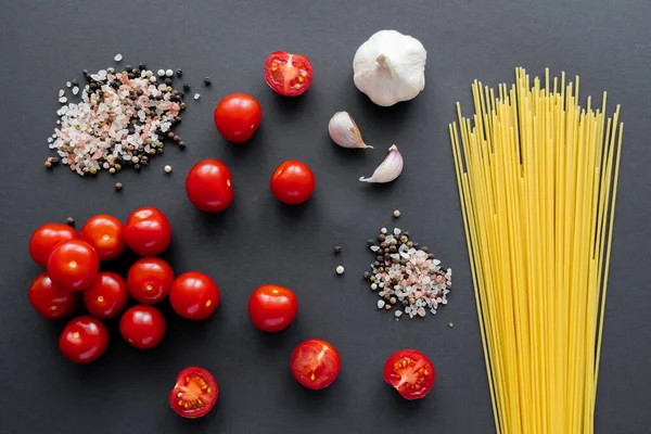 Vista superior de legumes frescos perto de especiarias e macarrão na superfície preta — Fotografia de Stock