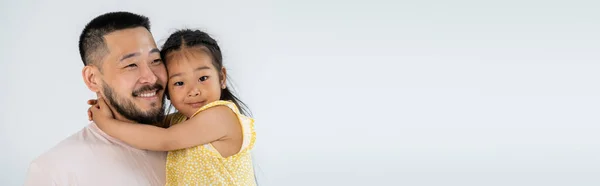 Alegre asiático hija abrazando feliz padre aislado en gris, bandera - foto de stock