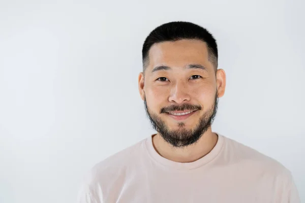 Ritratto di uomo asiatico con barba sorridente e guardando la fotocamera isolata sul grigio — Foto stock
