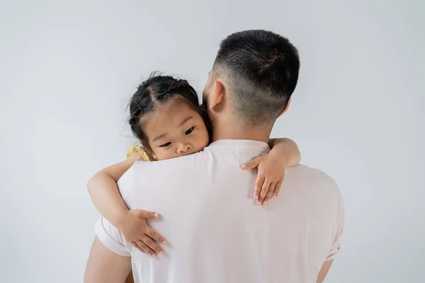 Indietro vista di padre con barba tenere in braccio asiatico prescolare figlia isolato su grigio — Foto stock