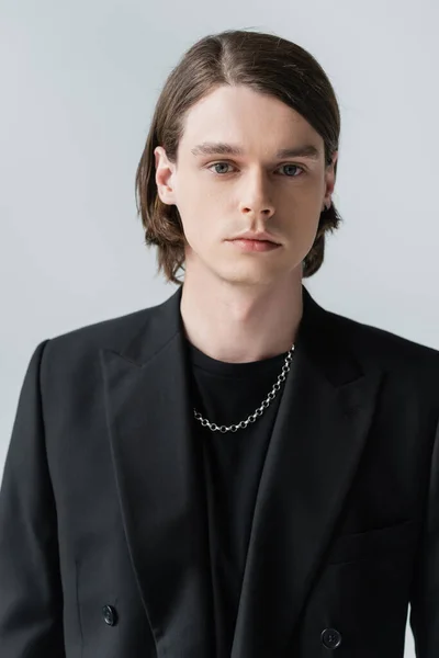 Portrait of young stylish man in jacket looking at camera isolated on grey — Stock Photo