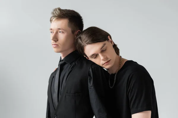 Junge gay schließen Augen, während in der Nähe Freund isoliert auf grau — Stockfoto