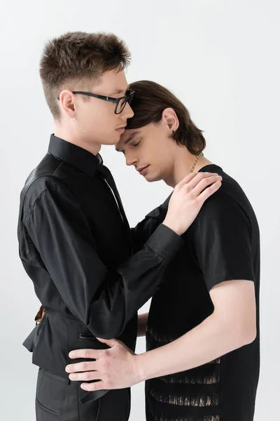 Jeune gay dans les lunettes câlin brunette copain isolé sur gris — Photo de stock