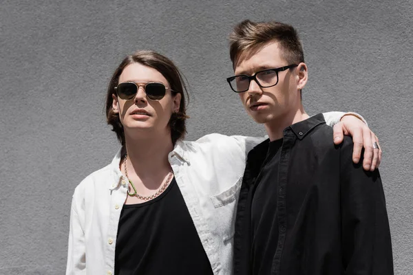 Retrato de elegante gay casal abraçando perto de construção ao ar livre — Fotografia de Stock