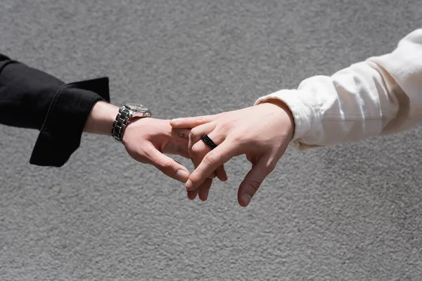 Coupé vue de jeune gay couple tenant la main à l'extérieur — Photo de stock