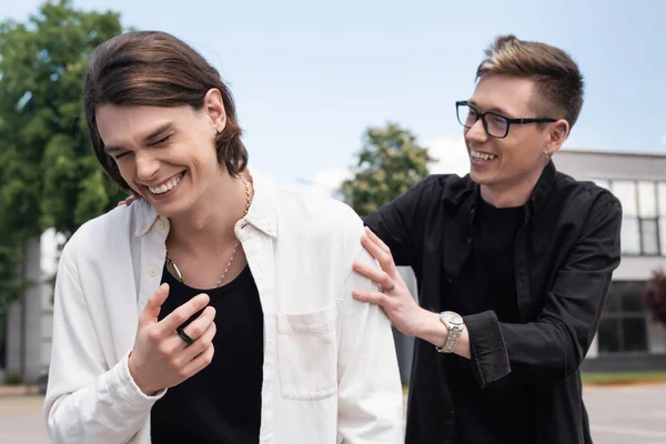 Cheerful young gay couple having fun on urban street — Stock Photo