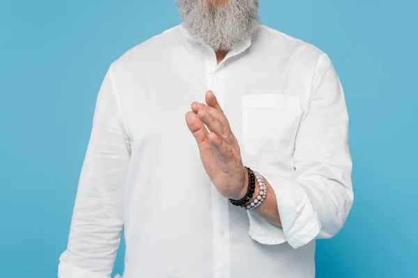Cropped view of bearded master guru showing blessing gesture isolated on blue — Stock Photo