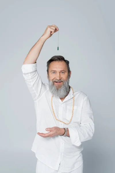 Positiver Meister-Guru mit Wünschelrute, der die Kamera isoliert auf Grau betrachtet — Stockfoto