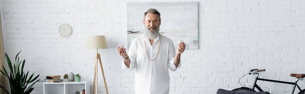 Bärtiger Meisterguru mit Selenitkristallen und Blick in die Kamera im Wohnzimmer, Banner — Stockfoto