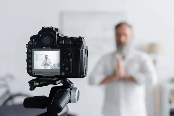 Verschwommener Guru meditiert mit betenden Händen in der Nähe der Digitalkamera zu Hause — Stockfoto