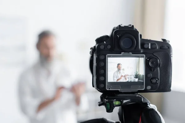 Selective focus of digital camera near senior spiritual guru at home — Stock Photo