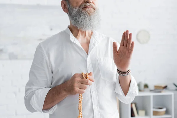 Partial view of master guru holding rosary and showing blessing gesture — Stock Photo