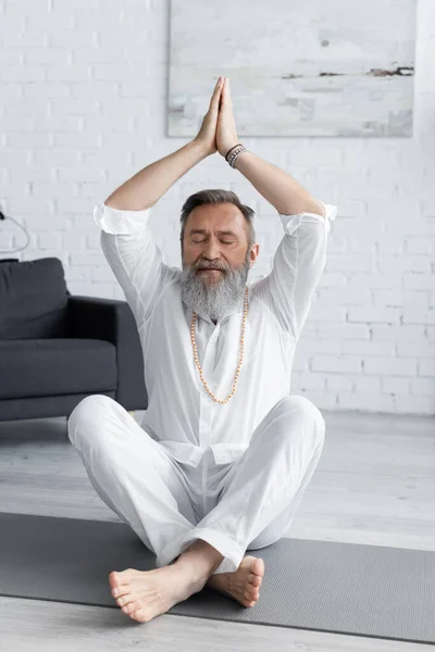 Senior guru man meditating in easy pose with raised hands and anjani mudra — Stock Photo