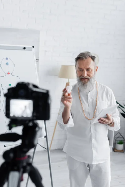 Senor heilungsguru mit digitaler tablette zeigt selenit stein an digitalkamera — Stockfoto