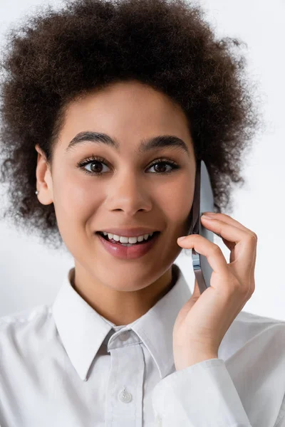 Retrato de la mujer afroamericana feliz hablando en el teléfono inteligente en casa - foto de stock