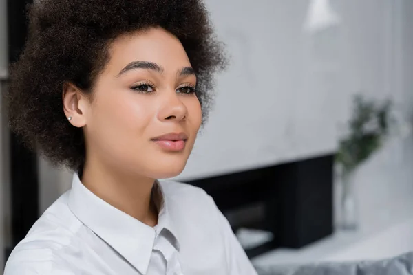 Portrait de femme américaine africaine rêveuse et bouclée en chemise blanche avec col — Photo de stock