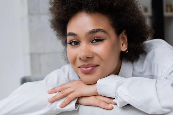Portrait of pleased and curly african american woman in white shirt with collar — Stock Photo