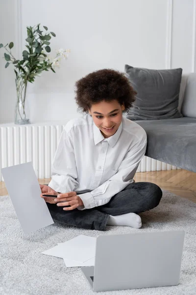 Lockige Afroamerikanerin zeigt leeres Dokument bei Videoanruf auf Laptop — Stockfoto