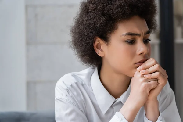 Upset african american woman in white shirt with clenched hands — Stock Photo