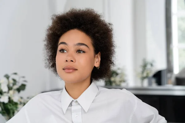 Portrait of curly african american in white shirt with collar looking away at home — Stock Photo