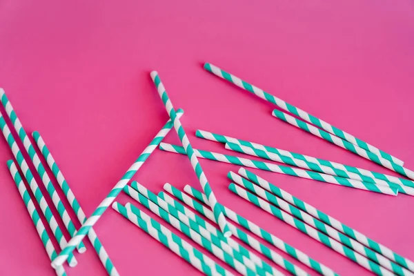 Top view of striped blue and white straws on pink background — Foto stock