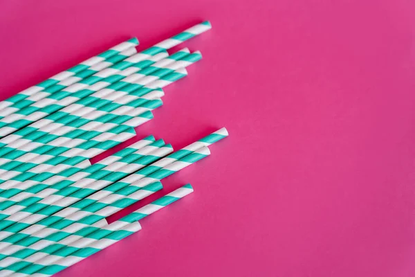 Top view of striped white and blue straws on pink background with copy space — Stock Photo