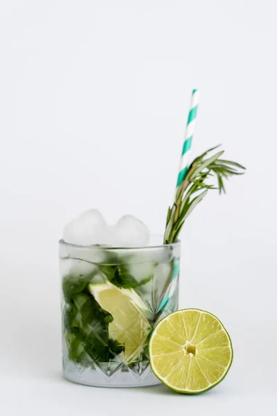 Kühles facettiertes Glas mit Mojito, Stroh und Eiswürfeln isoliert auf weiß — Stockfoto