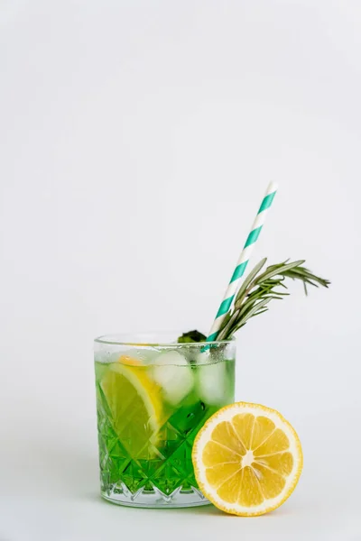 Cool faceted glass with lemon mojito, ice cubes and rosemary on white — Stock Photo