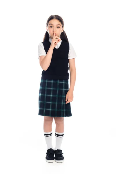 Full length of pupil showing shh gesture on white background — Stock Photo