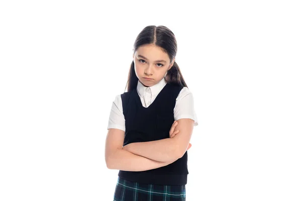 Upset schoolgirl crossing arms and looking at camera isolated on white — Stock Photo