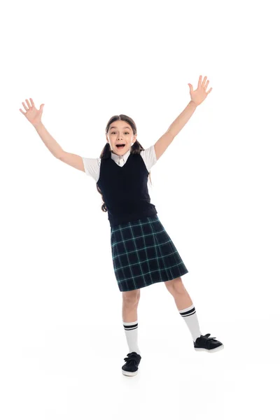 Longitud completa de la colegiala emocionada agitando las manos sobre fondo blanco - foto de stock