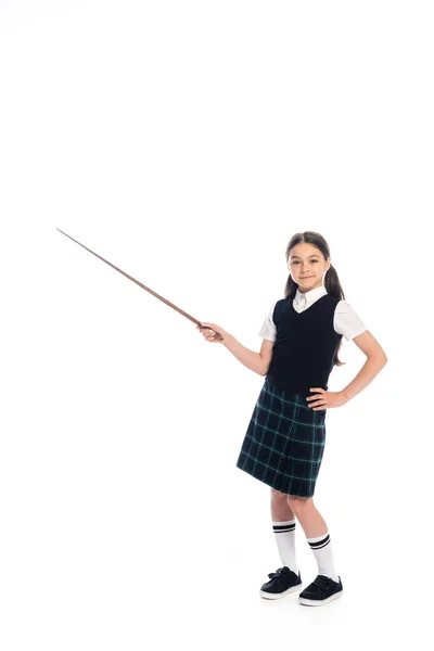 Full length of positive schoolchild holding pointer and looking at camera on white background — Stock Photo