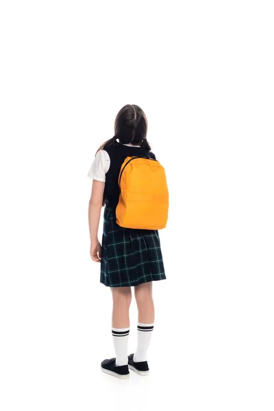 Back view of preteen schoolgirl with backpack standing on white background — Stock Photo