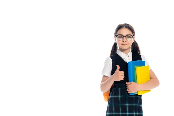 Pupil in eyeglasses holding books and showing thumb up isolated on white — Stock Photo