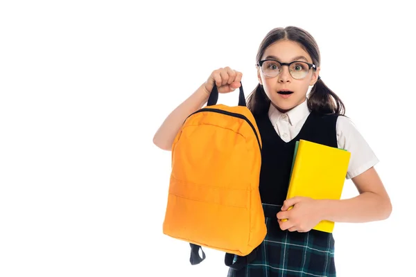 Shocked schoolkid holding books and backpack isolated on white — Stock Photo