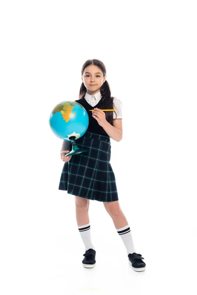 Longitud completa de preadolescente escolar sosteniendo lápiz y globo sobre fondo blanco - foto de stock