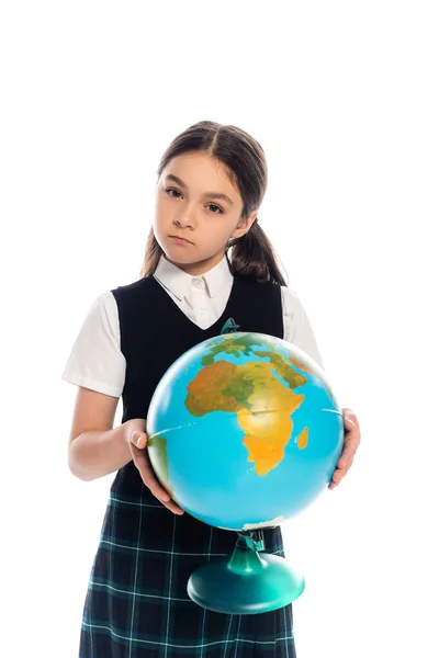 Niño escolar serio sosteniendo globo y mirando a la cámara aislada en blanco - foto de stock