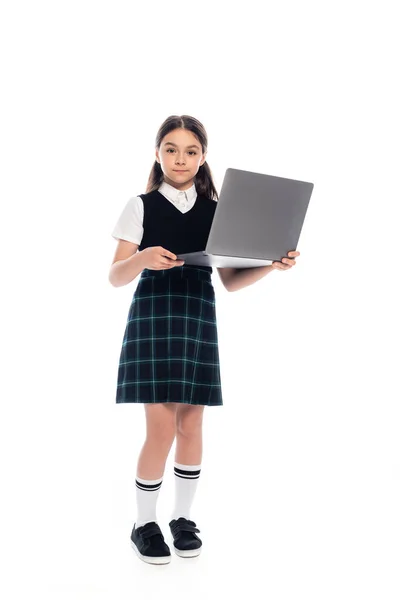 Comprimento total de estudante na saia segurando laptop no fundo branco — Fotografia de Stock