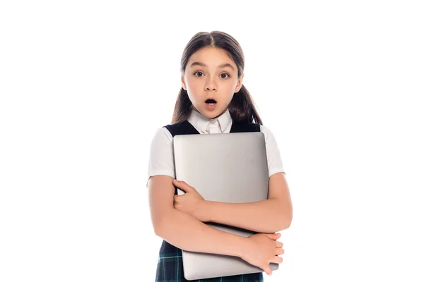 Shocked schoolkid holding laptop and looking at camera isolated on white — Stock Photo