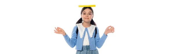 Écolier positif avec livre sur la tête et sac à dos montrant om mudra geste isolé sur blanc, bannière — Photo de stock