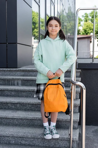 Preteen estudante segurando mochila enquanto estava de pé em escadas na rua urbana — Fotografia de Stock