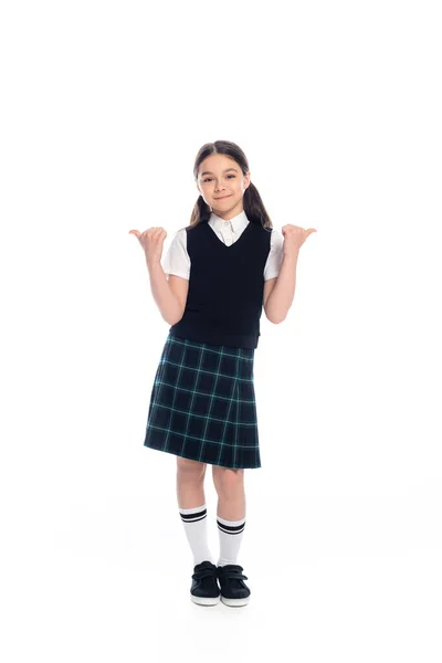 Lächelndes Schulkind zeigt mit den Fingern und blickt in die Kamera auf weißem Hintergrund — Stockfoto