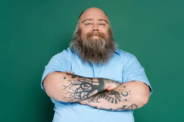 Heureux homme potelé avec barbe debout avec les bras croisés isolés sur vert — Photo de stock